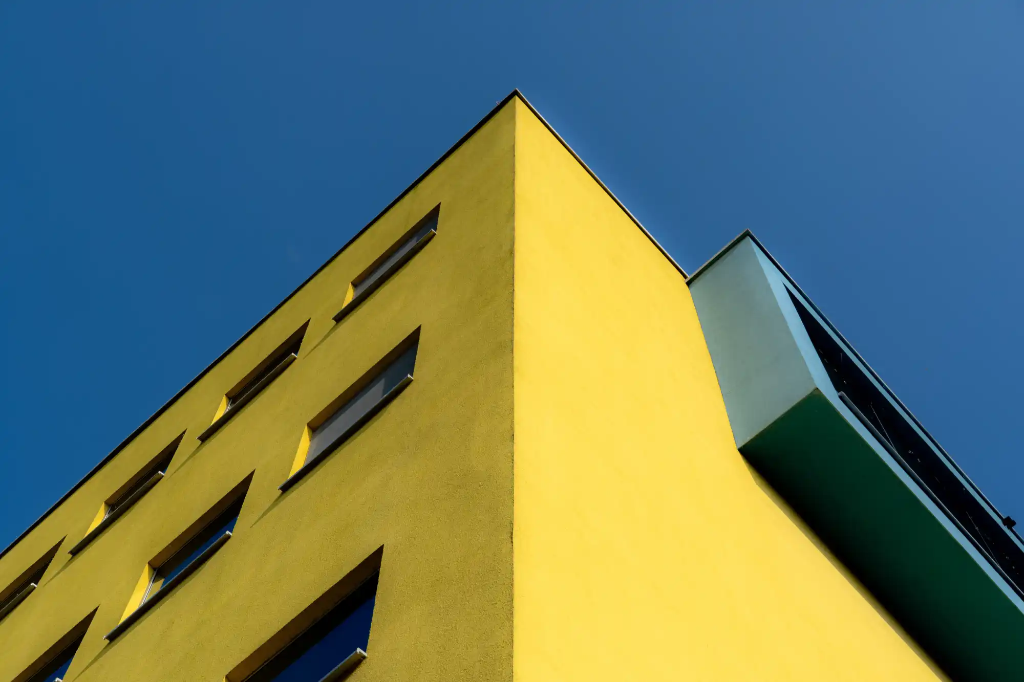 a colorful office building viewed at an angle, with the sky behind